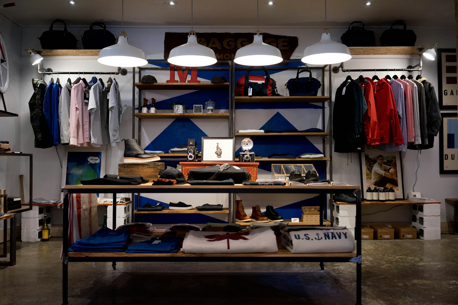 Interno di un negozio di abbigliamento con capi appesi e lampade calde